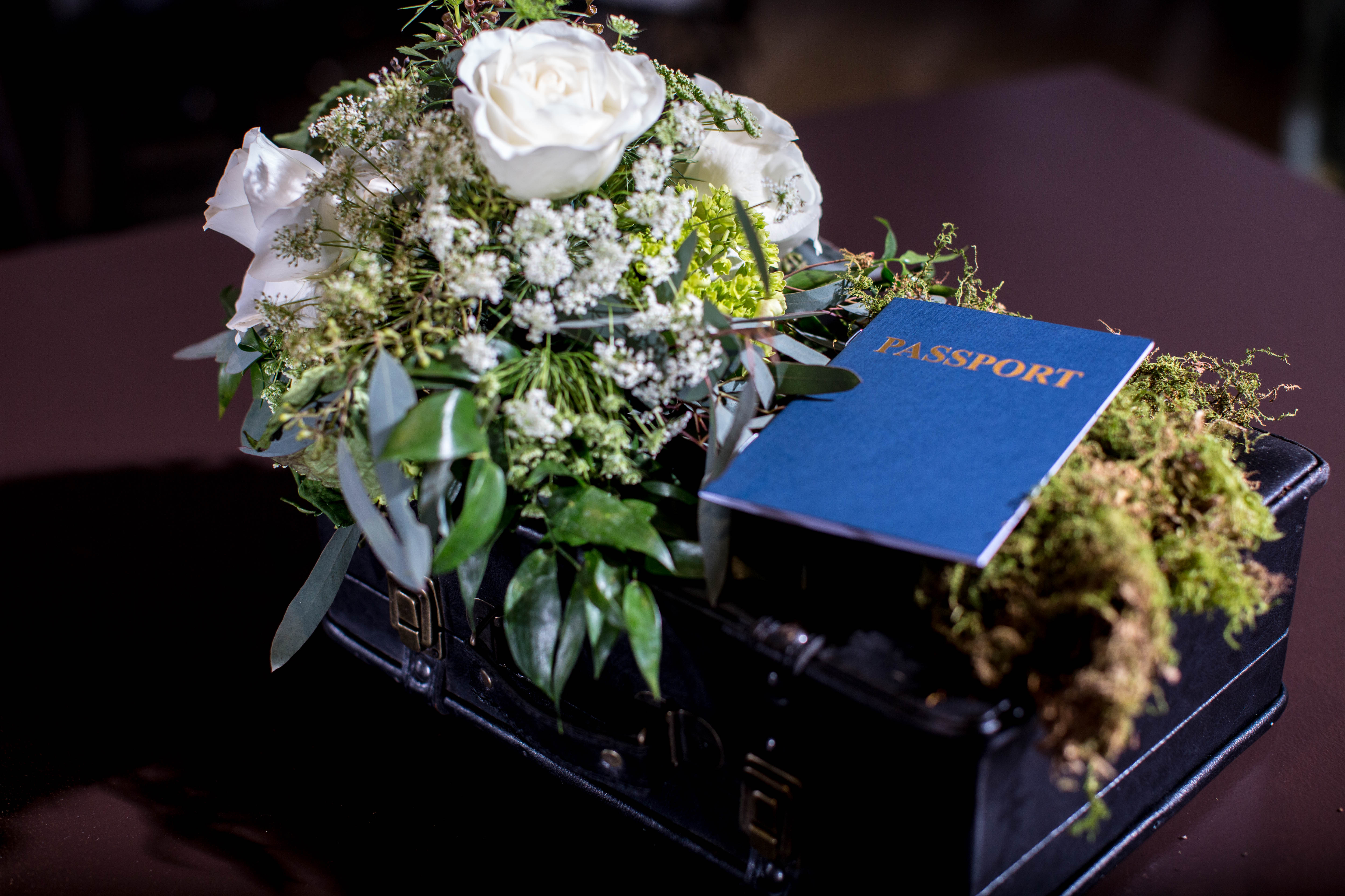 Vintage suitcases with flowers and passport centerpieces for Gabriela's global, vintage travel Bat Mitzvah party at VisArts in Rockville, Maryland | Pop Color Events | Adding a Pop of Color to Bar & Bat Mitzvahs in DC, MD & VA | Photo by Michael Temchine Photography