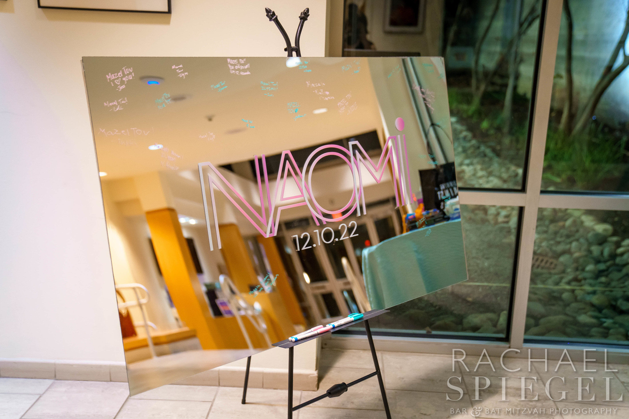 Naomi's glossy signage with pink and white color logo at Naomi's Pink and Purple Floral Bat Mitzvah Party at Temple Sinai in Washington, DC | Pop Color Events | Adding a Pop of Color to Bar & Bat Mitzvahs in DC, MD & VA | Photo by: Rachael Spiegel Photography