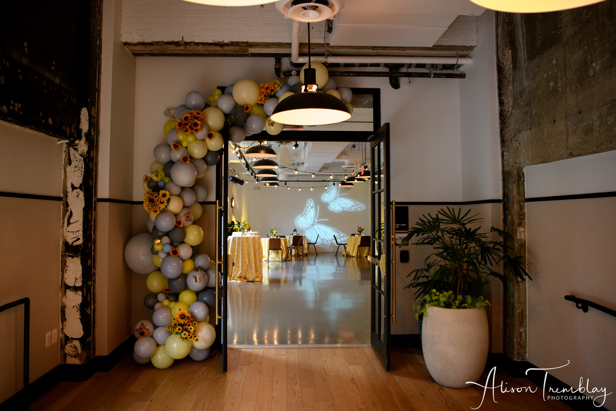 A balloon arch accented with sunflowers and butterflies at Charlotte's Sunflower and Butterfly Bat Mitzvah Party at Eaton In Washington, DC | Pop Color Events | Adding a Pop of Color to Bar & Bat Mitzvahs in DC, MD & VA | Photo by: Alison Tremblay