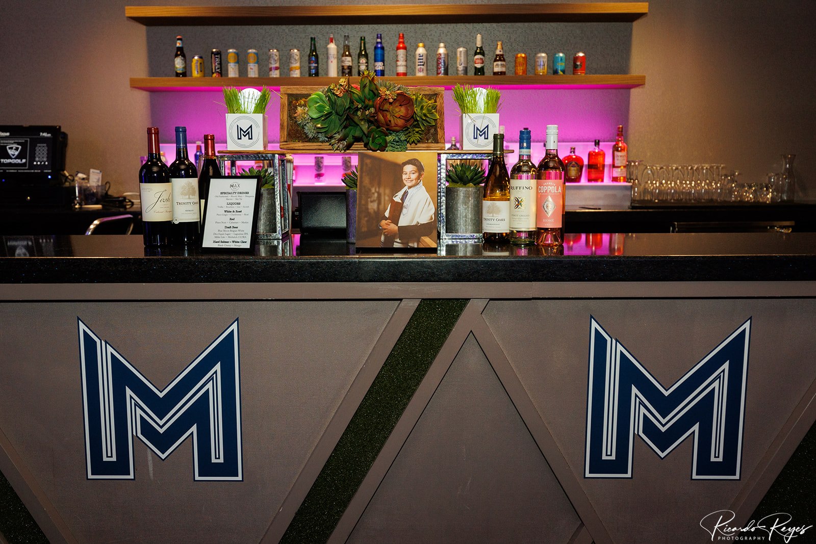 The bar at the reception with Max's blue and white logo at Max's Sporty Bar Mitzvah Party at Top Golf in Germantown, MD | Pop Color Events | Adding a Pop of Color to Bar & Bat Mitzvahs in DC, MD & VA | Photo by: Ricardo Reyes Photography