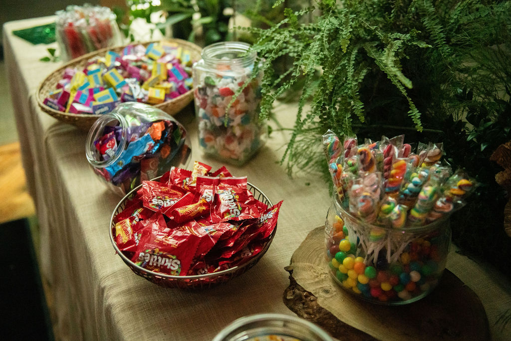 Amazing candy buffet of so many different choices decorated with more greenery at Rowan's Enchanted Forest B'nai Mitzvah at Bretton Wood Country Club in Germantown, MD | Pop Color Events | Adding a Pop of Color to Bar & Bat Mitzvahs in DC, MD & VA | Photo by: Lacey Ann Photography